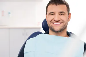 Hombre sonriente en un sillón dental